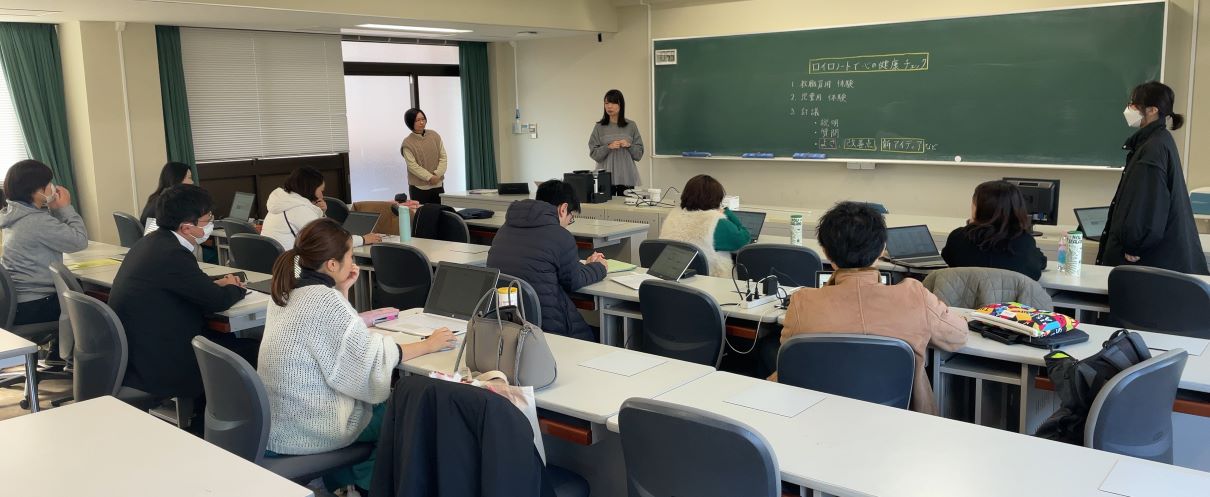 教室で院生が提案を聞き、意見を交わしている様子